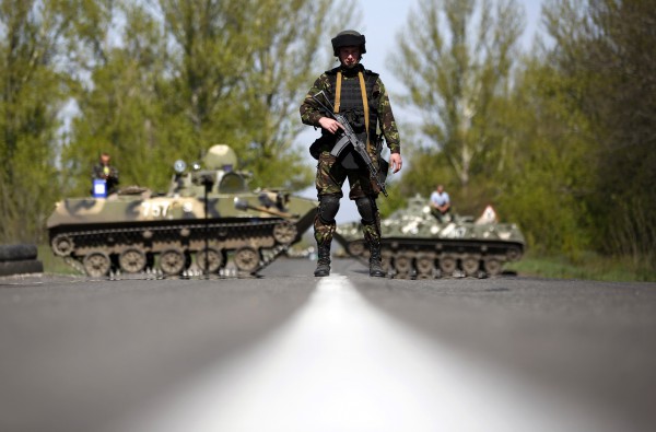 A Ukrainian soldier stand guard in front of armoured personnel carriers at a check point near the village of Malinivka, south-east of Slaviansk, in eastern Ukraine April 27, 2014. The de facto mayor of the Ukrainian city of Slaviansk said on Sunday mediators from the Organisation for Security and Cooperation in Europe who are seeking the release of a group of detained observers had arrived in the city.REUTERS/Marko Djurica (UKRAINE - Tags: POLITICS CIVIL UNREST MILITARY TPX IMAGES OF THE DAY)