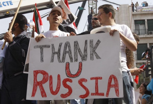 FILE - In this Oct. 12, 2011 file photo, supporters of the Syrian government hold a pro-Russian banner as they show their support for Syrian President Bashar Assad and to thank Russia and China for blocking a U.N. Security Council resolution condemning Syria for its brutal crackdown, during a demonstration in Damascus, Syria. Russian President Vladimir Putin is winning plaudits from many Syrians and Iraqis, who see Russia's military intervention in Syria as a turning point after more than a year of largely ineffectual efforts by the U.S.?led coalition battling the Islamic State group. (AP Photo/Muzaffar Salman, File)