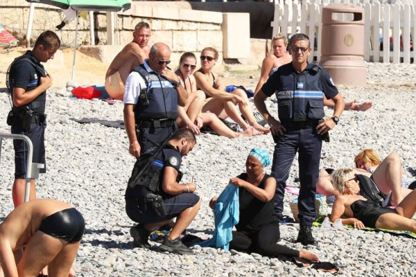 Police patrolling the promenade des anglais beach in Nice fine a woman for wearing a burkini. 23 August 2016. Please byline: Vantagenews.com