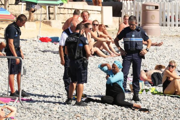 Police patrolling the promenade des anglais beach in Nice fine a woman for wearing a burkini. 23 August 2016. Please byline: Vantagenews.com