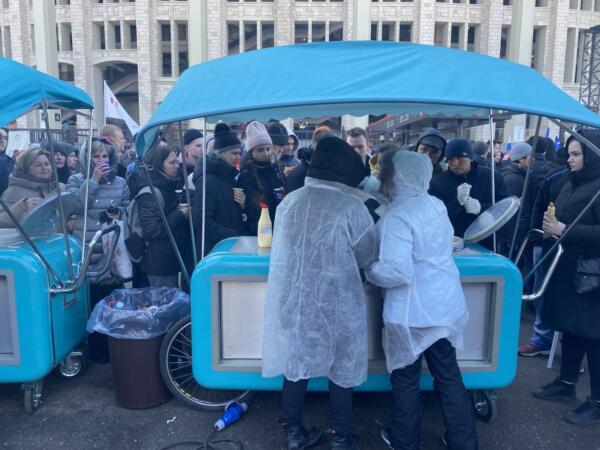 На концерте в Лужниках гости скучковались у палаток с бесплатной едой. Толпа ждёт миску гречки и чай